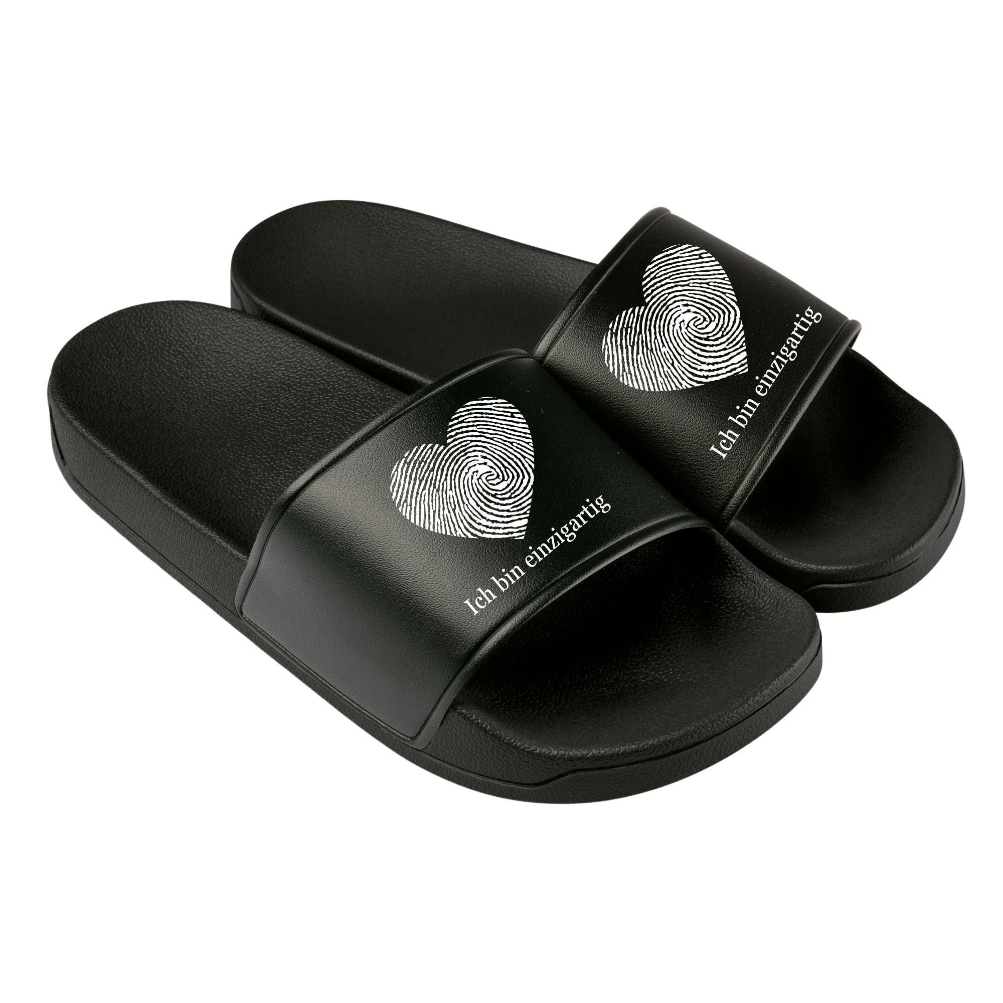 Schwarze Badelatschen mit weißem Herz-Fingerabdruck und der Aufschrift ‚Ich bin einzigartig‘ – schlichtes, starkes Design für selbstbewusste Kinder und Erwachsene