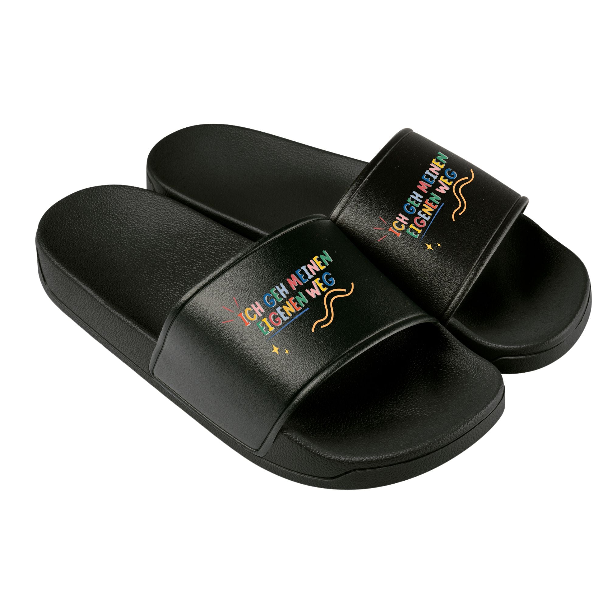 „Schwarze Badelatschen mit farbenfroher Aufschrift ‚Ich geh meinen eigenen Weg‘ und dekorativen Linien und Sternen – für selbstbewusste Kinder und Jugendliche.