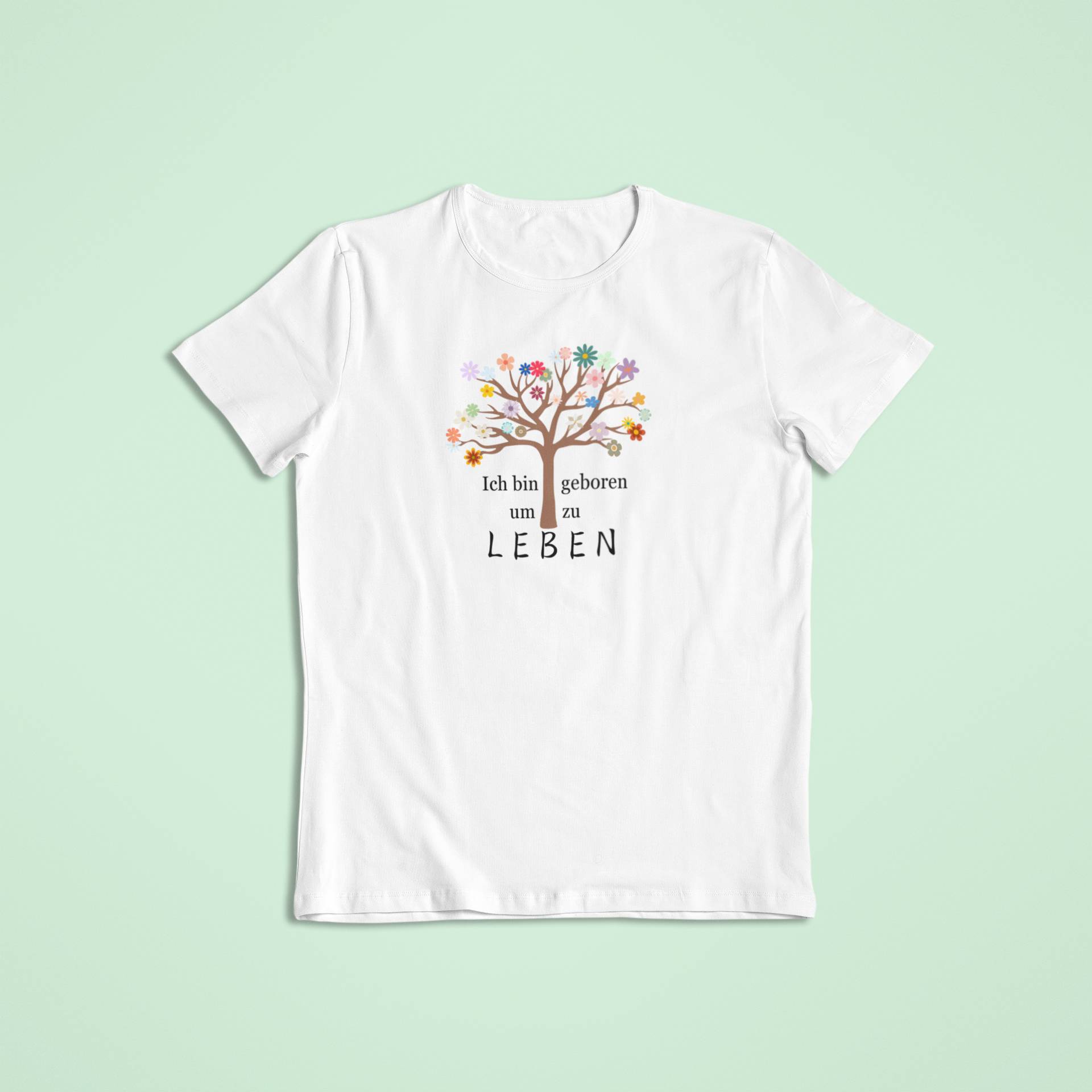 Weißes Kindershirt mit farbenfrohem Lebensbaum und der bestärkenden Aufschrift „Ich bin geboren um zu leben“.