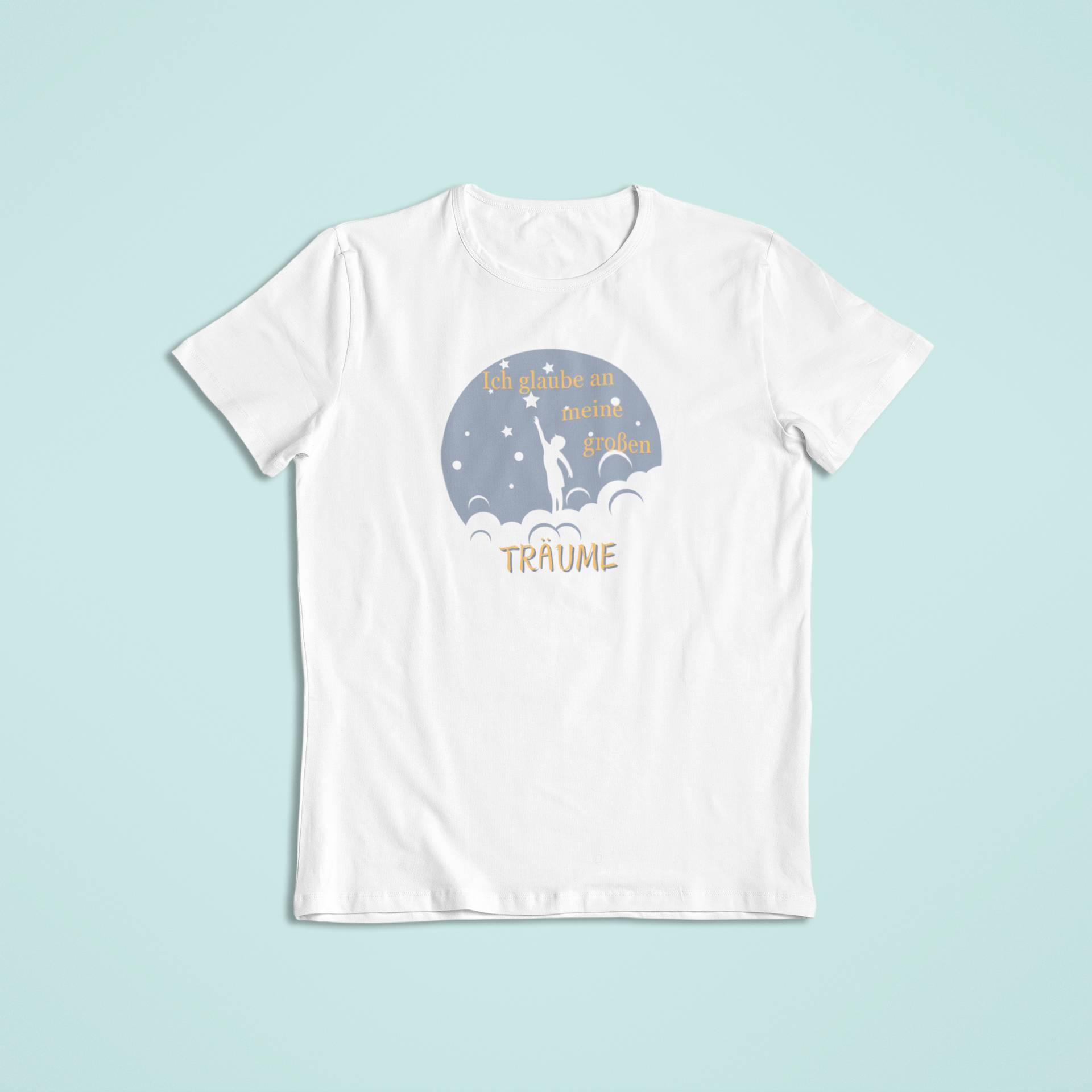 Weißes Kindershirt mit einem Design in Graublau und Gelb. Ein Kind auf Wolken greift nach einem Stern. Der Schriftzug „Ich glaube an meine großen TRÄUME“ ist freundlich und träumerisch gestaltet.