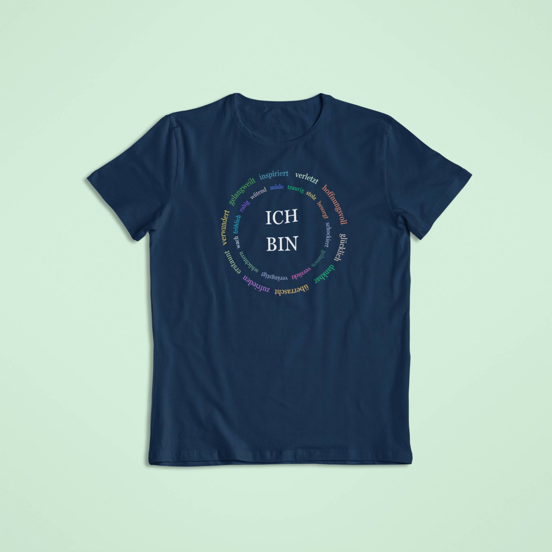 Dunkelblaues Kindershirt mit „ICH BIN“ in Weiß, umgeben von einem Kreis aus farbig gedruckten Emotionen und positiven Eigenschaften.