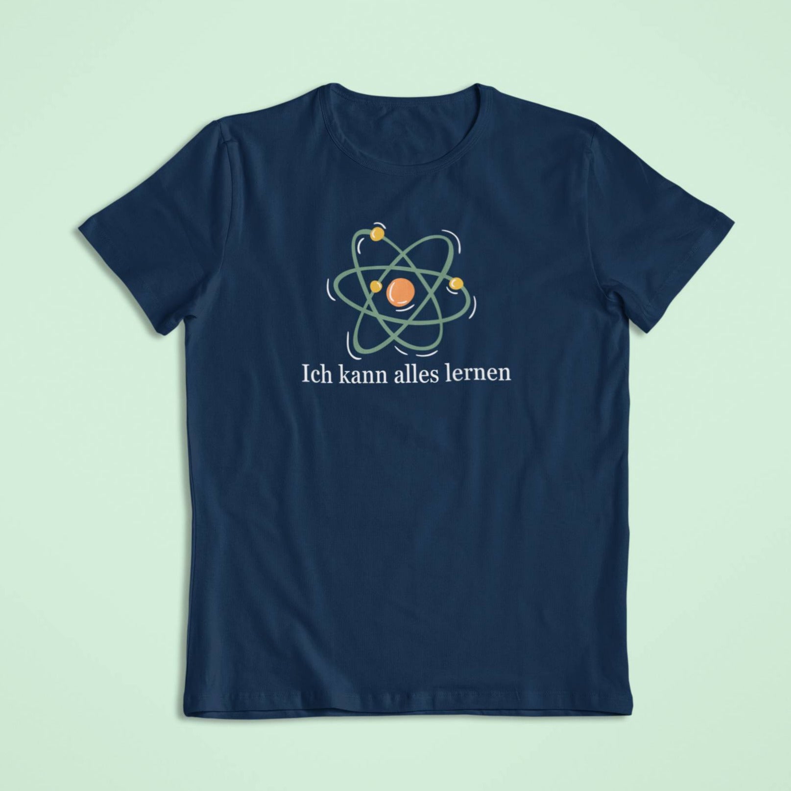 Dunkelblaues Kindershirt mit kräftig leuchtendem Atom-Symbol. Der Spruch „Ich kann alles lernen“ erscheint in weißer Schrift darunter.