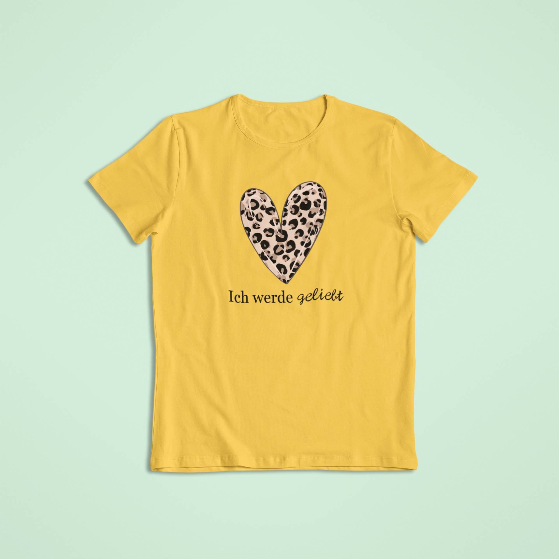 Gelbes T-Shirt mit liebevoller Aufschrift „Ich werde geliebt“ und einem Leopardenmuster-Herz – ein kraftvolles Zeichen für Zugehörigkeit, Selbstwert und Liebe im Alltag.