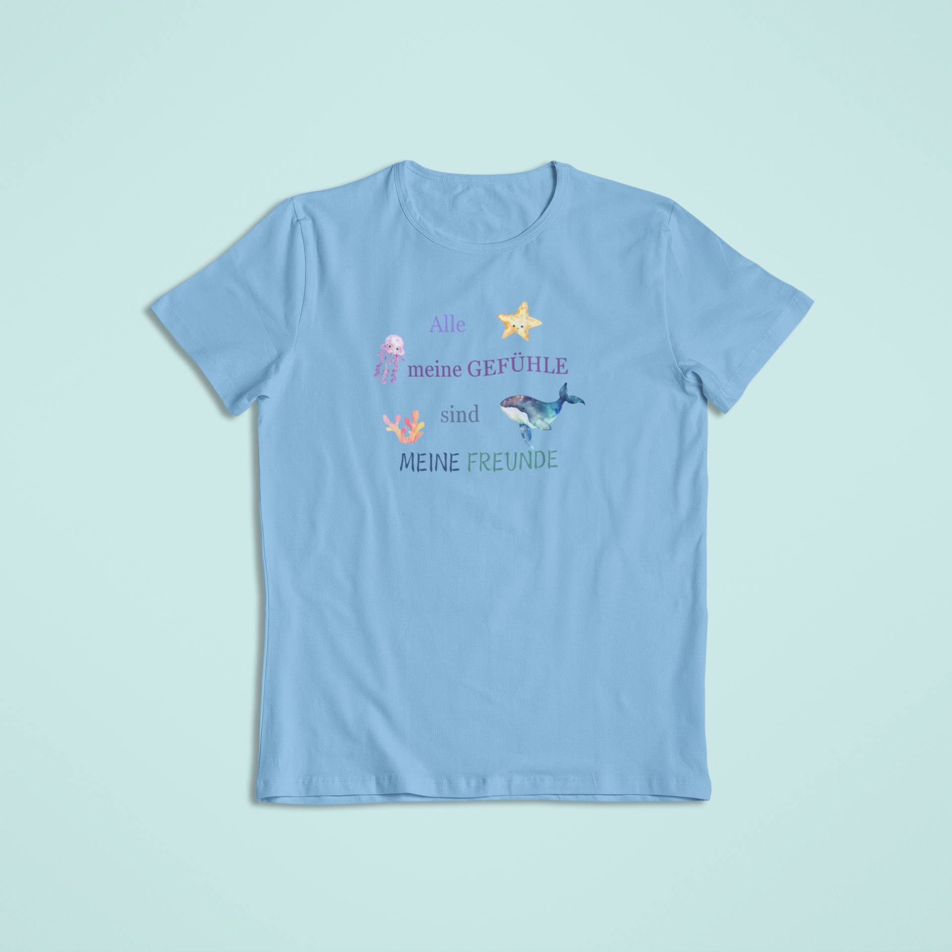 Hellblaues Kindershirt mit dem Spruch „Alle meine Gefühle sind meine Freunde“ und bunten Meerestieren wie Qualle, Seestern und Wal. Ein liebevolles Affirmationsshirt für emotionale Stärke und Selbstannahme.