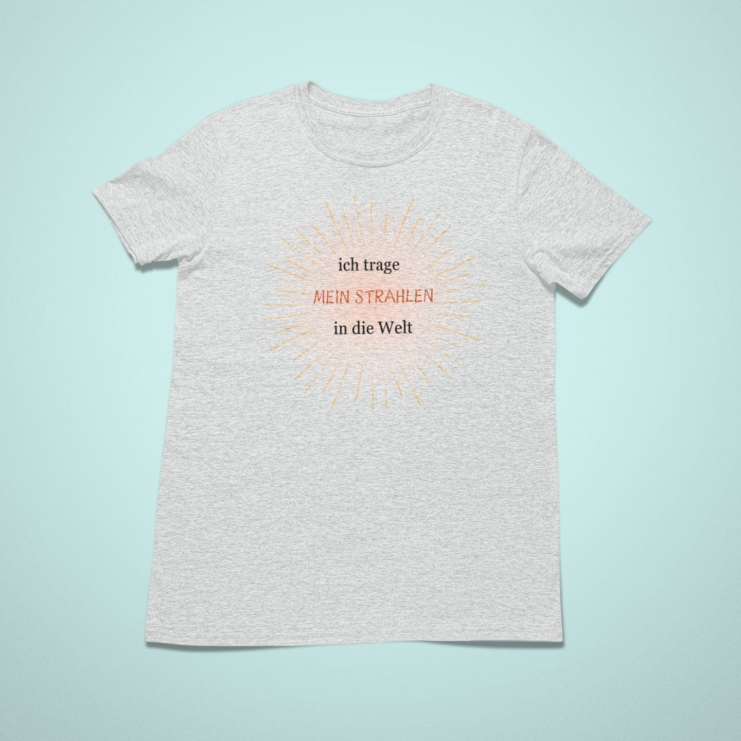 „Graues Kindershirt mit großem gelbgoldenem Sonnenstrahlenmotiv und dem Spruch ‚ich trage MEIN STRAHLEN in die Welt‘ in Schwarz und Rot.“