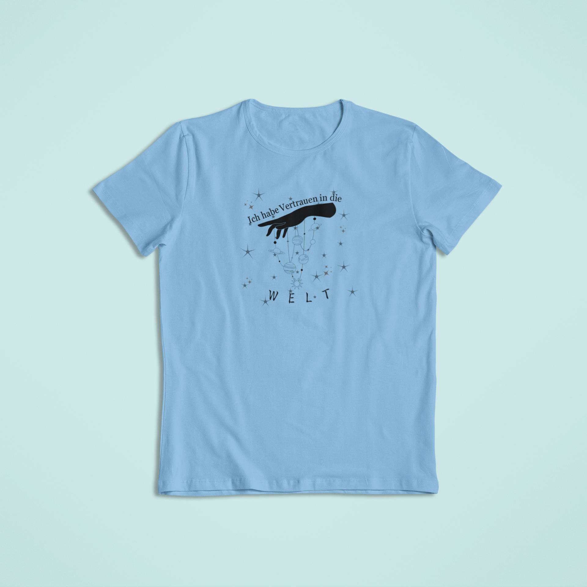 Kinder-T-Shirt in Himmelblau mit schwarzem Aufdruck „Ich habe Vertrauen in die Welt“ und Sternenmotiv, dazu eine Hand, die Figuren wie an Fäden hält.