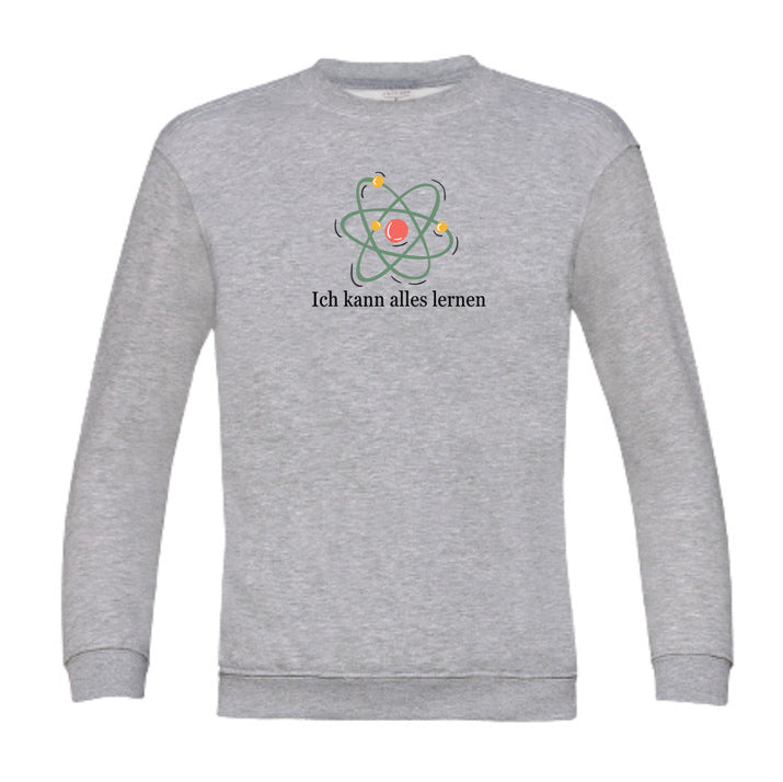 graues Kinder-Sweatshirt mit der Aufschrift „Ich kann alles lernen“ unter einer stilisierten bunten Atom-Grafik. Das Design vermittelt Neugier, Lernfreude und Wachstum.