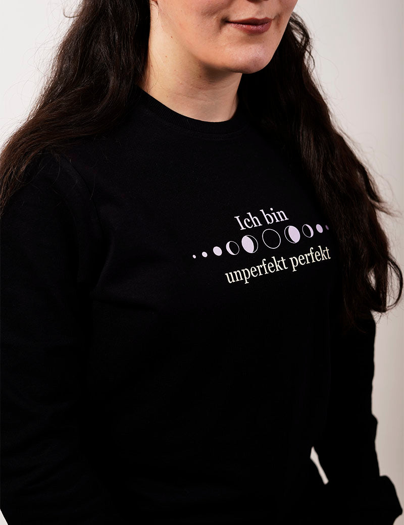 Nahaufnahme von einem schwarzen Frauen Pullover persönlicher wachstum mit weißer Schrift und Mondphasen ich bin unperfekt perfekt