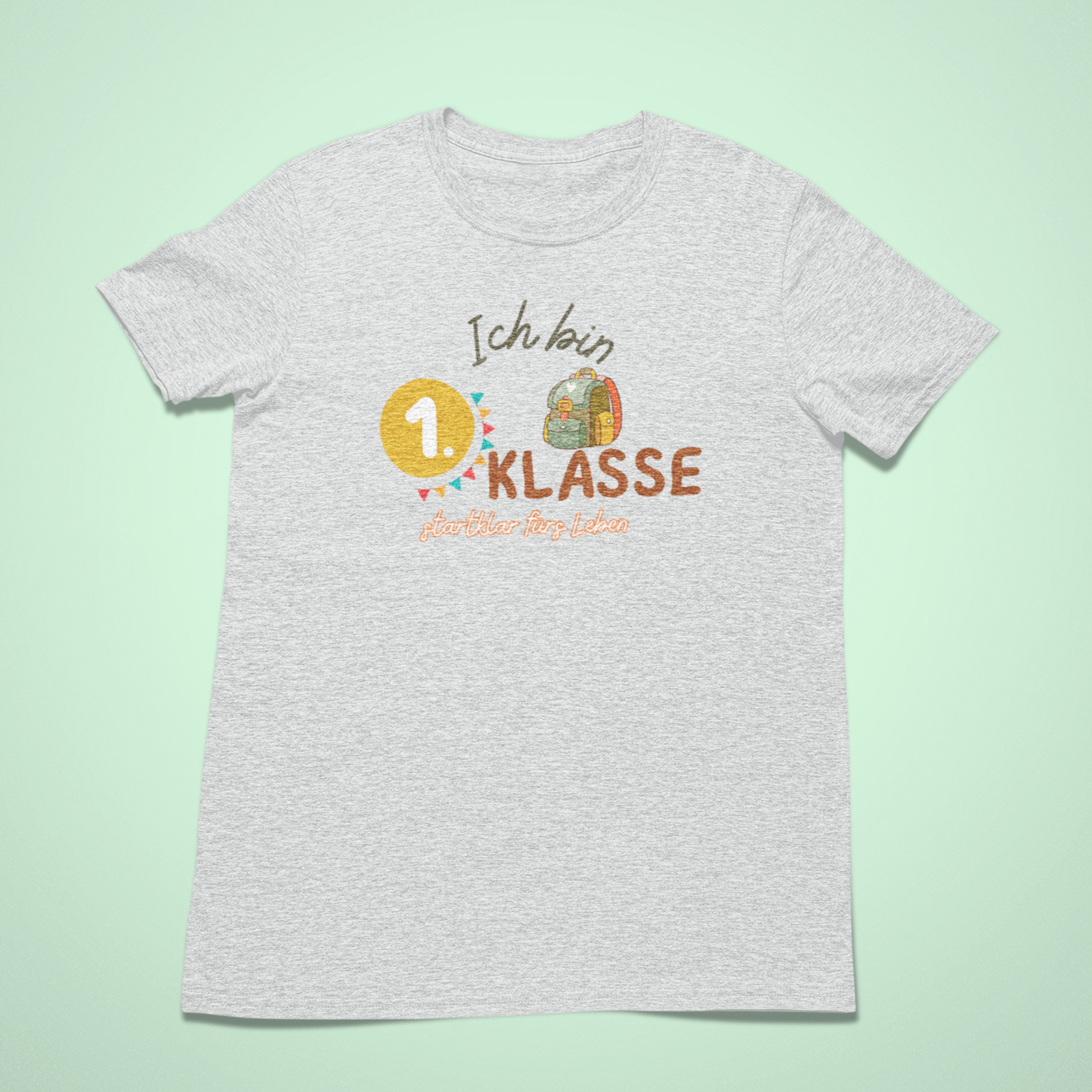 T-Shirt in Ash mit dem Aufdruck: Ich bin 1. Klasse – startklar fürs Leben. Bio-Einschulungs-T-Shirt von Sinachtsam