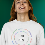 ein weißer pullover mit den Worten Ich bin und vielen kleineren bunten adjektiven im kreis 