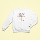 Weißes Kinder-Sweatshirt mit der Aufschrift „Ich bin geboren um zu leben“, begleitet von einem bunten Lebensbaum mit vielen farbigen Blüten. Das Design strahlt Lebensfreude, Selbstwert und Achtsamkeit aus.