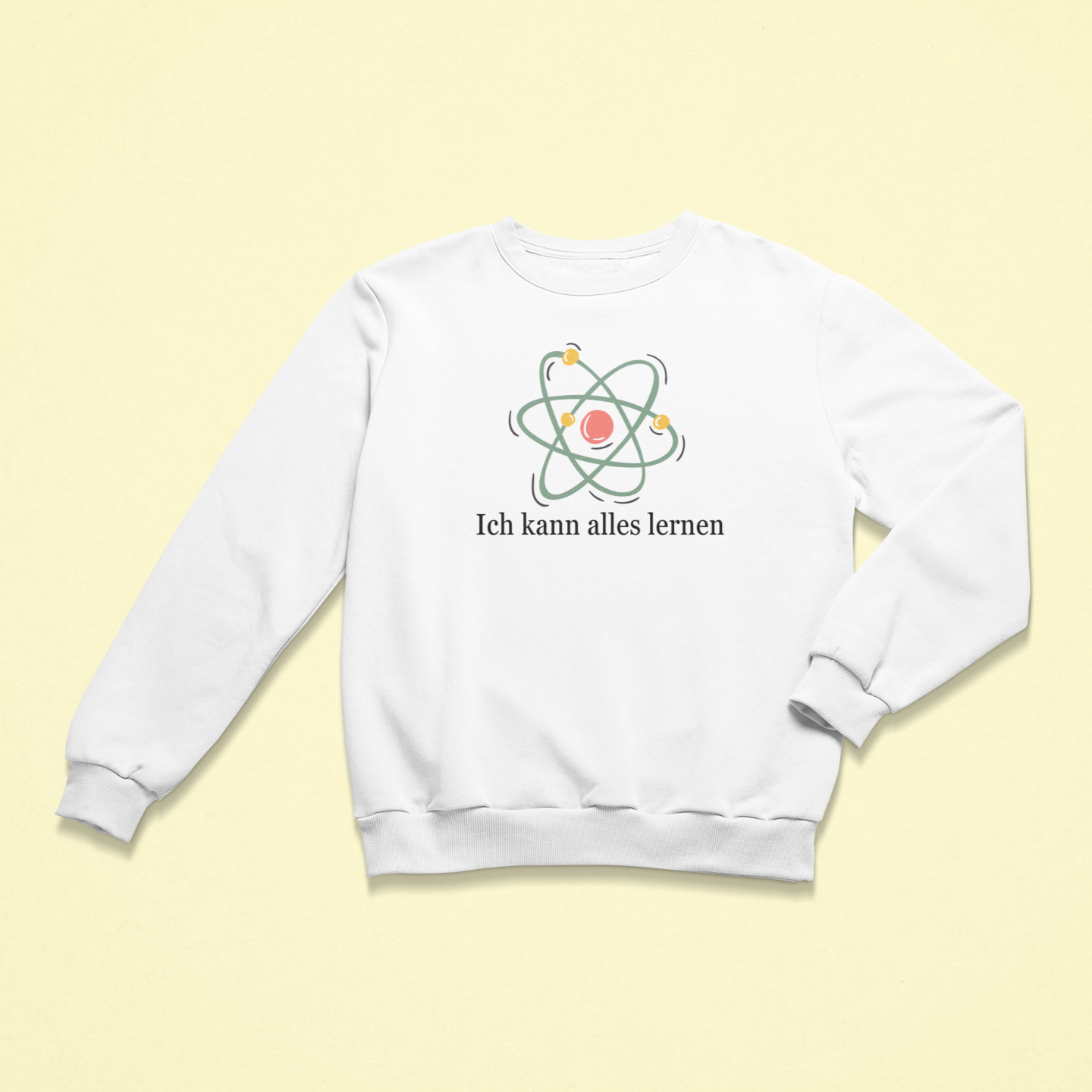 Weißes Kinder-Sweatshirt mit der Aufschrift „Ich kann alles lernen“ unter einer stilisierten bunten Atom-Grafik. Das Design vermittelt Neugier, Lernfreude und Wachstum.