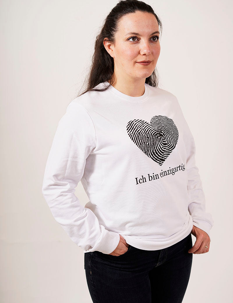 eine frau in einem weißen pullover mit einem fingerabdruck in einer herz form und der schrift ich bin einzigartig für einzigartigkeit