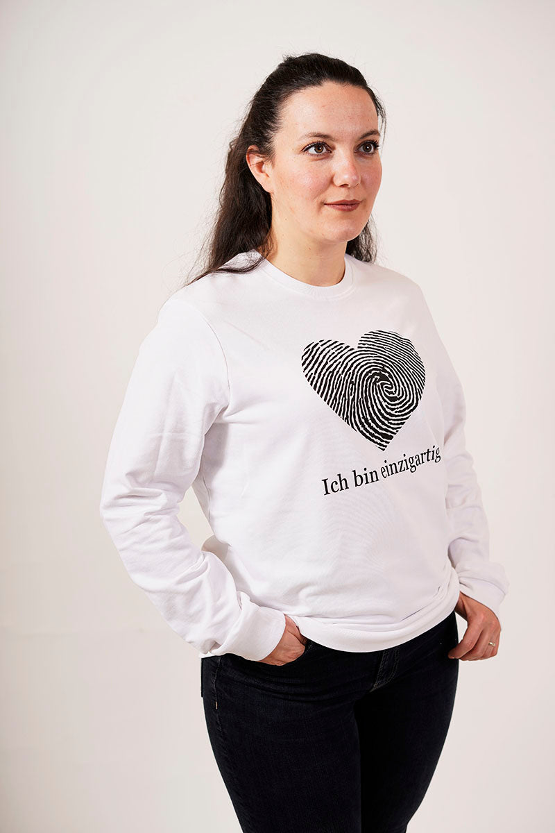 eine frau in einem weißen pullover mit einem fingerabdruck in einer herz form und der schrift ich bin einzigartig für einzigartigkeit