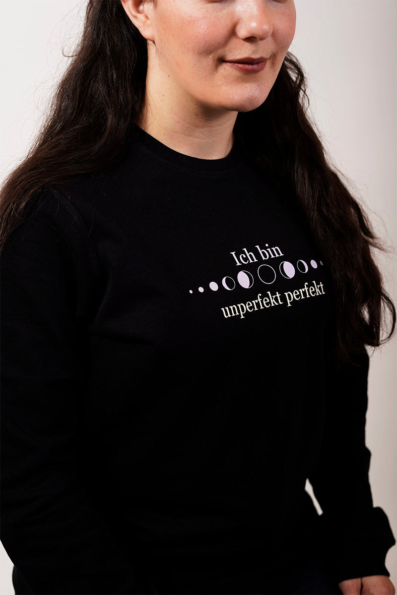 Nahaufnahme von einem schwarzen Frauen Pullover persönlicher wachstum mit weißer Schrift und Mondphasen ich bin unperfekt perfekt