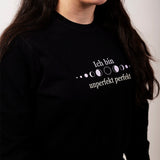 Nahaufnahme von einem schwarzen Frauen Pullover persönlicher wachstum mit weißer Schrift und Mondphasen ich bin unperfekt perfekt
