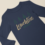 Navyfarbener Baby-Langarmbody mit weihnachtlichem Motiv aus Tannenbäumen und dem Schriftzug „Leuchten statt Leisten“, flach auf hellem Hintergrund präsentiert.