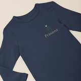 Navyfarbener Baby-Langarmbody mit kleinem Frontprint „Präsenz“ und Geschenk-Illustration, flach präsentiert.