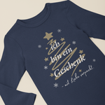 Navyfarbener Baby-Langarmbody mit weihnachtlichem Tannenbaum-Design und dem Spruch „Ich bin ein Geschenk – mit Liebe verpackt“, flach auf hellem Hintergrund präsentiert.