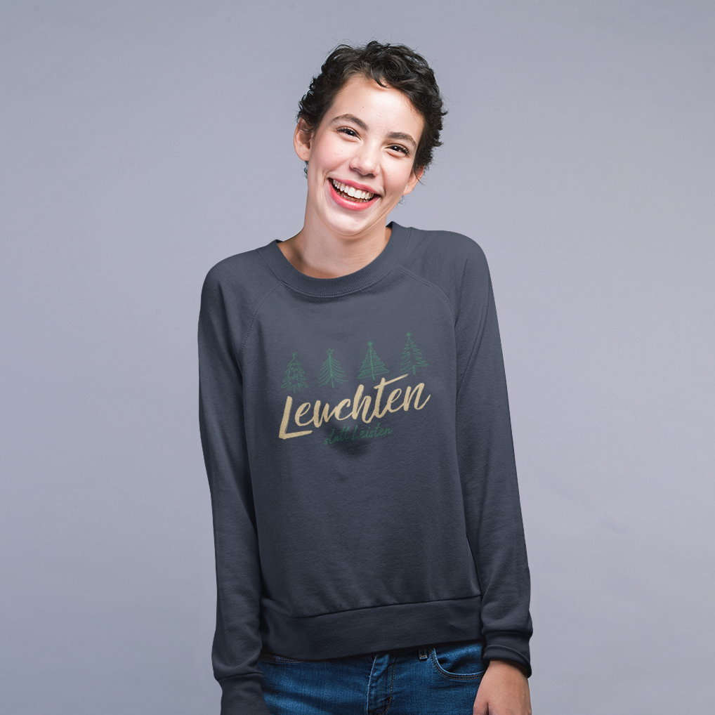 Lachende Frau trägt navyfarbenes „Leuchten statt Leisten“ Sweatshirt in einem hellen Studio.