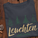 Dunkelblaues Weihnachtssweatshirt mit grünen Tannenbäumen und goldener Aufschrift „Leuchten statt Leisten“ – achtsame Weihnachtsmode von Sinachtsam.