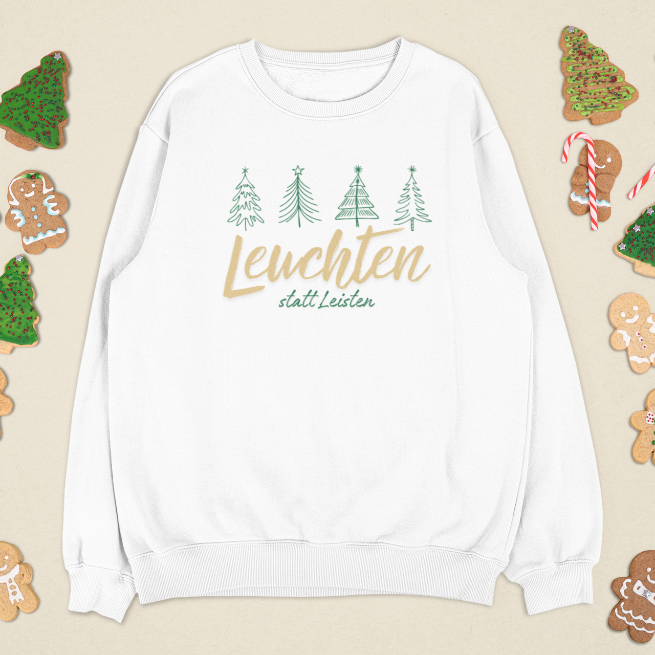 Weißes „Leuchten statt Leisten“ Sweatshirt, festlich arrangiert mit Weihnachtskeksen und winterlichen Details.
