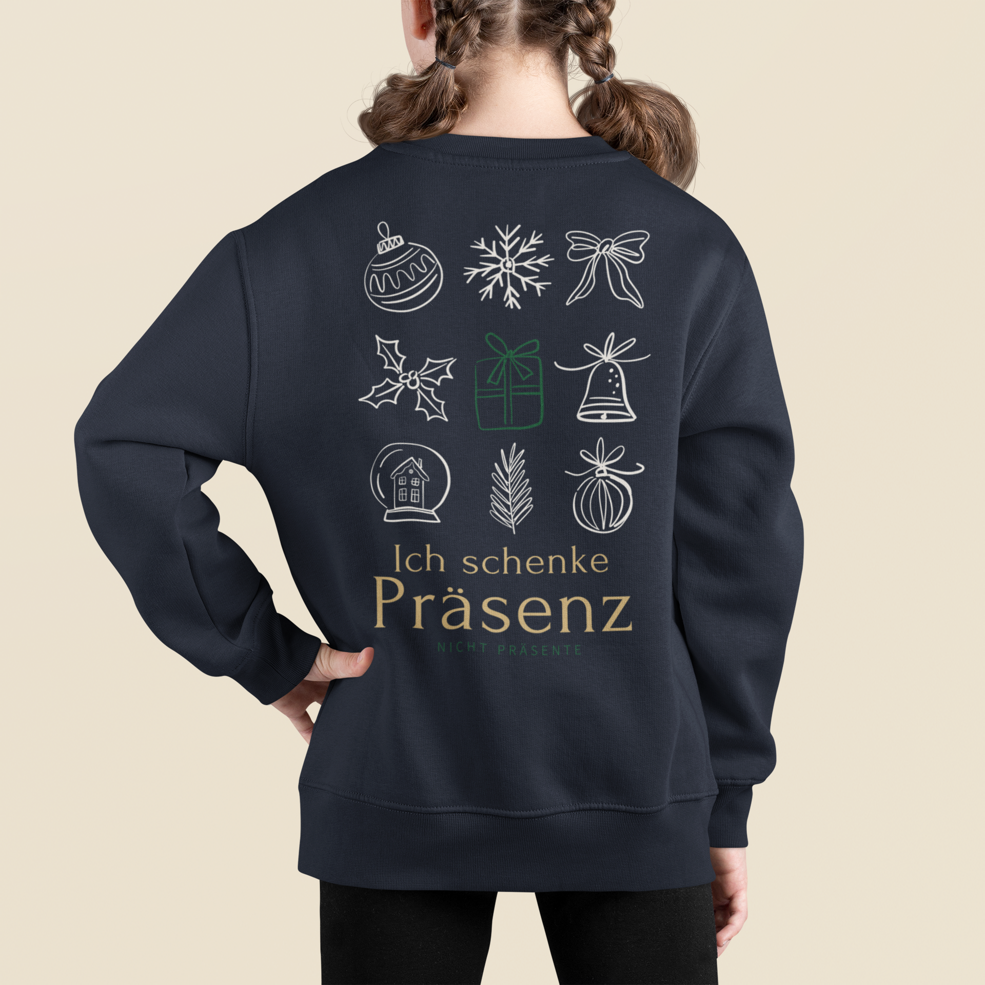 Kind trägt ein navyfarbenes Sweatshirt mit großem weihnachtlichen Backprint: lineare Weihnachtssymbole und der Schriftzug „Ich schenke Präsenz – nicht Präsente“. Ansicht von hinten vor hellem Hintergrund.