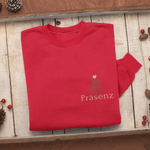 Gefaltetes rotes Sweatshirt auf Holztablett mit kleinem Frontprint Präsenz und einem grünen Geschenk-Icon mit Herz