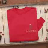 Gefaltetes rotes Sweatshirt auf Holztablett mit kleinem Frontprint Präsenz und einem grünen Geschenk-Icon mit Herz